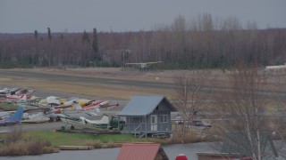 AK0001_0686 - 4K aerial stock footage tracking small plane taking off, Lake Hood Seaplane Base, Anchorage, Alaska