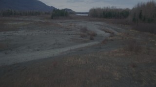 AK0001_0699 - 4K aerial stock footage flying low over riverbed, trees, during winter, Knik River, Alaska