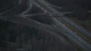 AK0001_0710 - 4K aerial stock footage flying by Glenn Highway through forest, during winter, Chugiak, Alaska