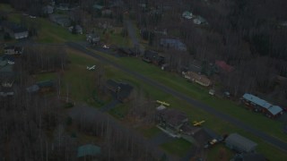 AK0001_0711 - 4K aerial stock footage flying by neighborhood near landing strip, winter, Chugiak, Alaska