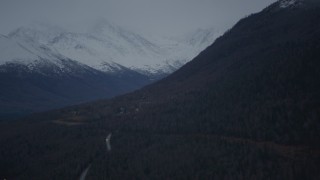AK0001_0717 - 4K aerial stock footage fly by homes at foot of Chugach Mountain, snow-capped peaks, Chugiak, Alaska