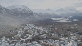 AK0001_0752 - 4K aerial stock footage snowy residential neighborhood Eagle River Valley, wooded hill, Eagle River, Alaska