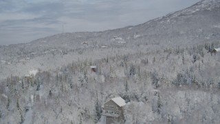 AK0001_0753 - 4K aerial stock footage homes on snow-covered wooded slope, Eagle River Valley, Eagle River, Alaska