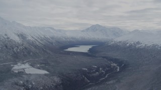 AK0001_0774 - 4K aerial stock footage flying by snowy Chugach Mountains and Eklutna Lake, Alaska