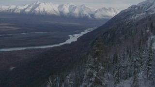 AK0001_0783 - 4K stock footage aerial video fly low over treetops, reveal Knik River Valley, snowy Chugach Mountains, Alaska
