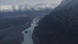 AK0001_0785 - 4K aerial stock footage tilt from river to reveal Old Glenn Highway, bridge, snowy Chugach Moutains, Knik River Valley, Alaska