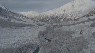 AK0001_0801 - 4K aerial stock footage descending into frosty valley, snow-covered Chugach Mountains, Alaska