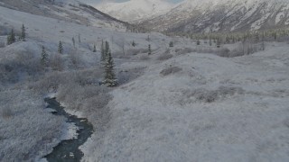 AK0001_0803 - 4K aerial stock footage flying low beside river, frosty valley, snowy Chugach Mountains, Alaska