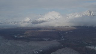 AK0001_0848 - 4K aerial stock footage flying by Talkeetna Mountains, clouds, and Matanuska River Valley, Alaska in winter