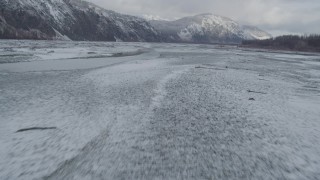 AK0001_0853 - 4K aerial stock footage flying near snowy Talkeetna Mountains, over icy Matanuska River Valley, Alaska