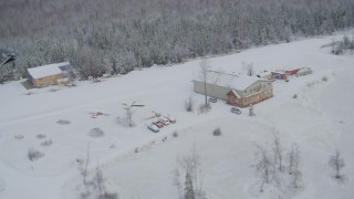 AK0001_0862 - 4K aerial stock footage ascend and fly away from snowy King Ranch, Sutton, Alaska