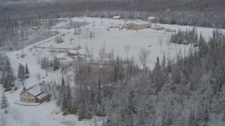 AK0001_0865 - 4K aerial stock footage orbiting snowy King Ranch, descend to runway, landing, Sutton, Alaska
