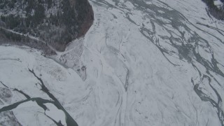 AK0001_0878 - 4K aerial stock footage bird's eye view of the icy, snow covered river during winter, Matanuska River Valley, Alaska