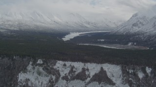 AK0001_0881 - 4K aerial stock footage flying by Chugach Mountains and snow-covered Matanuska River Valley, Alaska