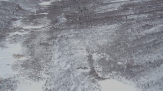 AK0001_0885 - 4K aerial stock footage tilt up to snow-covered Chugach Mountain slope, Alaskan Wilderness