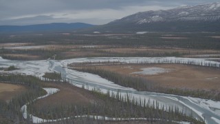 AK0001_0893 - 4K aerial stock footage approaching tree lined, snow covered rivers during winter in the Tazlina River Valley, Alaska