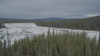 AK0001_0898 - 4K aerial stock footage river, trees, reveal frozen, snow covered riverbed, during winter, Tazlina River Valley, Alaska