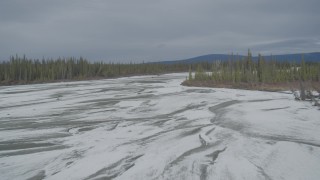 AK0001_0899 - 4K aerial stock footage flying over frozen, snow covered riverbed during winter, Tazlina River Valley, Alaska