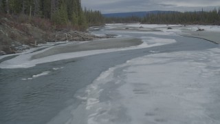 AK0001_0901 - 4K aerial stock footage flying low over a tree lined, snowy river during winter, Tazlina River Valley, Alaska