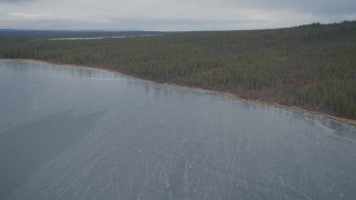AK0001_0904 - 4K aerial stock footage flying over icy waters, snow covered forest, during winter, Twin Lakes,  Alaska