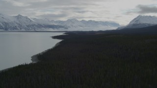 AK0001_0912 - 4K stock footage aerial video flying beside Tazlina Lake during winter toward snow covered Tazlina Glacier, Alaska