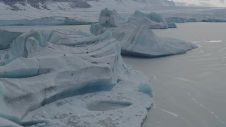 AK0001_0917 - 4K aerial stock footage flying over snowy, glacial ice during winter in Tazlina Lake, Alaska
