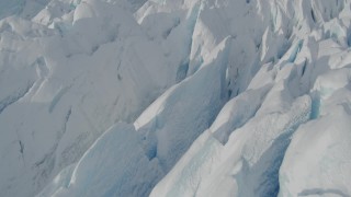AK0001_0931 - 4K aerial stock footage flying over snow covered surface of the Tazlina Glacier, tilt to a bird's eye view, Alaska