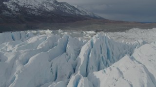 AK0001_0935 - 4K aerial stock footage flying over snow covered surface of the Tazlina Glacier, tilt down, Alaska