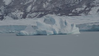 AK0001_0941 - 4K aerial stock footage flying by glacial ice during winter, near edge of snow covered glacier, Tazlina Lake, Alaska