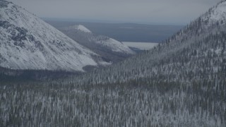 AK0001_0956 - 4K aerial stock footage flying by Saint Anne Lake, snow-covered slopes, during winter, Chugach Mountains, Alaska