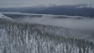 AK0001_0964 - 4K aerial stock footage approach Saint Anne Lake, through mist above snowy Chugach Mountains, Alaska