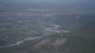 AK0001_0973 - 4K aerial stock footage flying over wooded gorge, forested cliff, during winter, Klutina River, Alaska