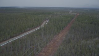 AK0001_0975 - 4K aerial stock footage approaching power lines during winter, revealing Trans-Alaska Pipeline, Alaska