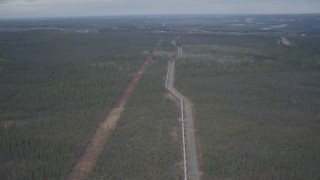 AK0001_0985 - 4K aerial stock footage follow pipeline, descend towards forest, during winter, Trans-Alaska Pipeline, Alaska