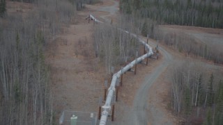 AK0001_0989 - 4K aerial stock footage follow pipeline as it enters the ground, during winter, Trans-Alaska Pipeline, Alaska