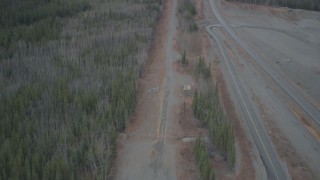 AK0001_0990 - 4K aerial stock footage fly between forest and road during winter, revealing Trans-Alaska Pipeline, Alaska