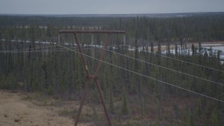 AK0001_1001 - 4K aerial stock footage follow pipeline past power lines and ponds during winter, Trans-Alaska Pipeline, Alaska