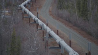 AK0001_1004 - 4K aerial stock footage following pipeline through forest during winter, Trans-Alaska Pipeline, Alaska