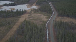 AK0001_1007 - 4K aerial stock footage follow pipeline through forest, during winter, Trans-Alaska Pipeline, Alaska
