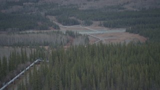 AK0001_1008 - 4K aerial stock footage approaching pipeline spanning Tazlina River, winter, Trans-Alaska Pipeline, Alaska