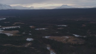 AK0001_1047 - 4K aerial stock footage flying over icy ponds in an evergreen forest, Alaskan Wilderness