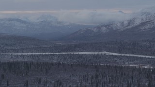 AK0001_1054 - 4K aerial stock footage snow capped Talkeetna Mountains and wooded foothills, Alaskan Wilderness