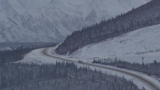 AK0001_1055 - 4K stock footage aerial video Glenn Highway winding around snowy Talkeetna Mountain, Alaskan Wilderness