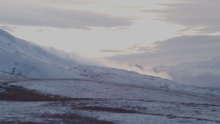 AK0001_1062 - 4K aerial stock footage flying down a snowy slope with Talkeetna Mountains in the distance, Alaska