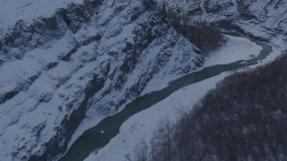 AK0001_1069 - 4K aerial stock footage a river at the bottom of a canyon, snowy cliffs, Talkeetna Mountains, Alaska