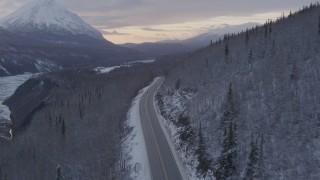 AK0001_1102 - 4K aerial stock footage Glenn Highway toward King Ranch, snow on ground, Sutton, Alaska, twilight