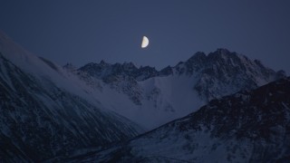 AK0001_1105 - 4K aerial stock footage the moon over the snow covered Chugach Mountains at night, Alaska