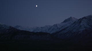 AK0001_1108 - 4K stock footage aerial video the moon over the snow covered Chugach Mountains at night, Alaska