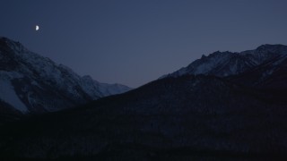 AK0001_1111 - 4K stock footage aerial video the moon over the snow covered Chugach Mountains at night, Alaska