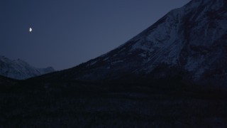 AK0001_1112 - 4K stock footage aerial video the moon over the snow covered Chugach Mountains at night, Alaska